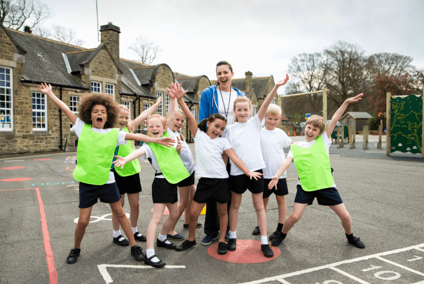 Image of a Hockey team in green bibs posing for a photo in a sports hall